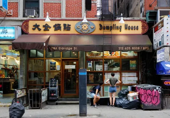 The Vanessa’s Dumpling House storefront on Eldridge Street, with a gold sign in Chinese and English over a brown awning.