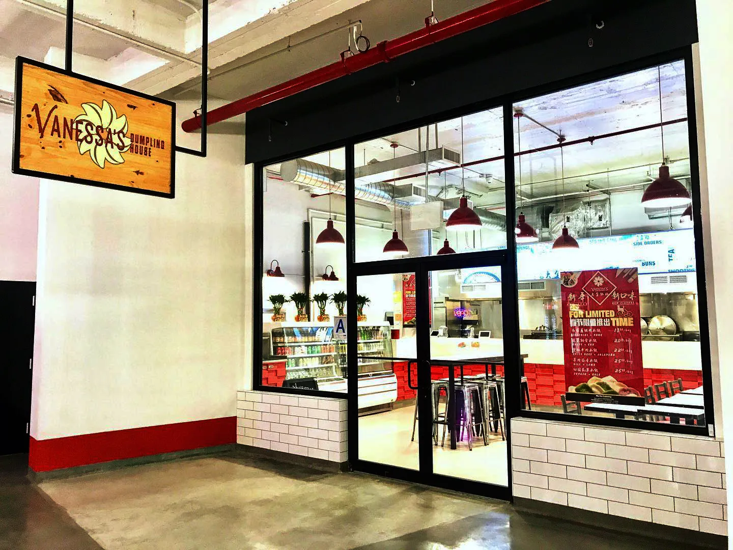 The glass-fronted Vanessa’s Dumpling House entrance in Long Island City, with a hanging Vanessa’s sign.